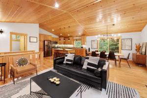Una sala de estar con un sofá negro y una cocina. en Modern Lake Tahoe Retreat Ski and Swim, en Tahoe Vista