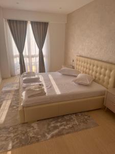 ein Schlafzimmer mit einem großen Bett mit einem großen Fenster in der Unterkunft Eroilor Apartments in Curtea de Argeş + 27 Fotos