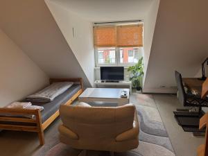 a living room with a bed and a chair at LaViva Home 24 - Studio mit Galerie in Lübeck +4 photos