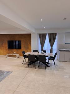 una sala da pranzo con un tavolo e sedie nere di Eroilor Apartments a Curtea de Argeş