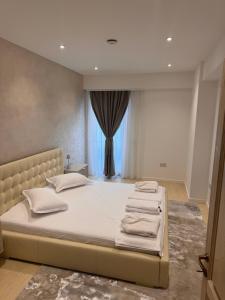 una camera da letto con un letto grande con asciugamani sopra di Eroilor Apartments a Curtea de Argeş