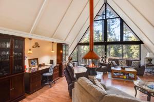 a living room with a vaulted ceiling and large windows at Woodside Hideout - Hop Away from Activities in Tahoma