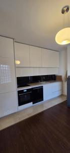 a kitchen with white cabinets and a black dishwasher at Neoma's Home in Peje