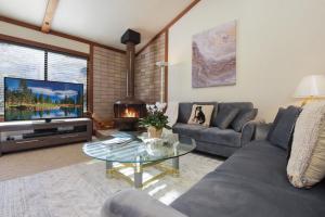 a living room with a couch and a table and a tv at Valley View Bliss - Nearby Bike Trails & Beach in Olympic Valley +23 photos