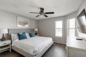 グランドプレーリーにあるLanding Apartments - Grand Prairieのベッドと天井扇風機のある寝室