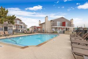 a swimming pool with lounge chairs and a house at Landing at Quail Ridge - Grand Prairie in Grand Prairie
