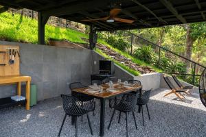 Un patio con mesa y sillas y parrilla. en Dreamy cabin in Comasagua, La Libertad, en Comasagua