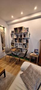 Appartement design et loisirs proche Saverne في Dettwiller: غرفة معيشة مع طاولة ورف كتاب