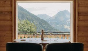 a table with wine glasses in front of a window at Chalet Flachaire in Abondance