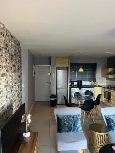 a kitchen and living room with a table and chairs at Home relaxation in the city in Cape Town