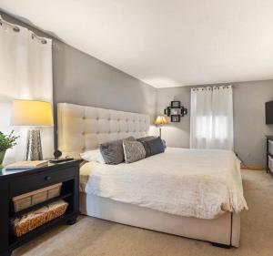 Un dormitorio con una gran cama blanca y un escritorio. en Elegant New England Home with Private Pool, en Woburn