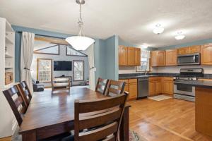 Una cocina con una mesa de madera y un comedor. en Elegant New England Home with Private Pool, en Woburn