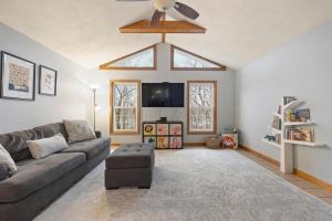 Una sala de estar con un sofá y un televisor. en Elegant New England Home with Private Pool, en Woburn