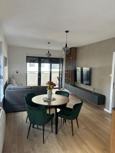 a living room with a table and chairs and a couch at Apartman Andrea in Trebinje +8 photos