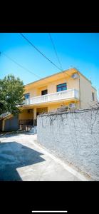 a yellow building with a fence in front of it at Villa 59 in Shkodër