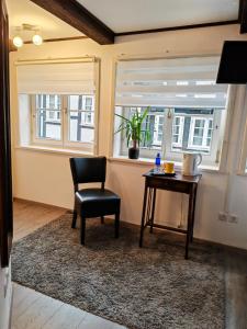 ein Stuhl und ein Tisch in einem Zimmer mit Fenstern in der Unterkunft Café Pension in Celle + 30 Fotos