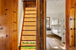 Una escalera de madera que conduce a un dormitorio con una litera. en Cute Romantic Cabin With Hot Tub 5 Min from Lake, en Crestline