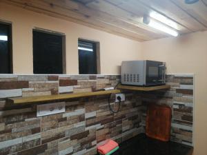 pokój z kuchenką mikrofalową na ceglanej ścianie w obiekcie Casa ecologica, autosuficiente en Lomo Blanco, dentro de una casa rodeada de naturaleza w mieście San Juan de la Rambla