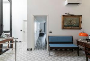 a living room with a blue chair and a mirror at Itaca Porto Loft& Rooms in Milazzo