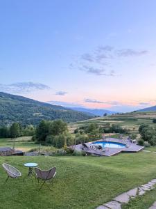 a yard with two chairs and a table and a pool at M.A.K.home in Vyshka