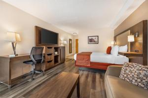 a hotel room with a bed and a desk at Best Western Smiths Falls Hotel in Smiths Falls