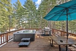 a deck with a hot tub and a picnic table and an umbrella at Tahoe City Retreat - For 8 in Tahoe City