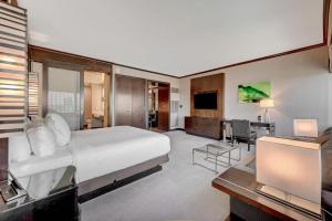 a bedroom with a large white bed and a television at Luxurious Vdara High Rise Room, City Skyline Views, King Bed, Free Valet in Las Vegas