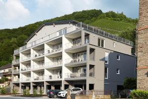 a large apartment building with cars parked in front of it at Ferienwohnung Edeltrud Deluxe Alte Brauerei Bernkastel-Kues in Bernkastel-Kues