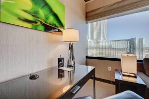 a room with a desk with a lamp and a window at Luxurious Vdara High Rise Room, City Skyline Views, King Bed, Free Valet in Las Vegas +20 photos