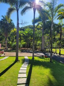 a walkway in a park with palm trees at Villa Pomerode Hospedagem - Suítes com conforto e aconchego conectados com a Natureza in Pomerode