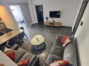 a living room with a couch and a table at Central 2 bdr Flat St Lazaros -Arsinoe Lodge in Larnaka