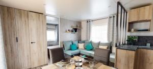 a living room with a blue couch and a table at Mobil home Cap ferret les viviers siblu in Lège-Cap-Ferret