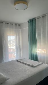 a bedroom with a bed with a window and a lamp at MBv Budva in Budva