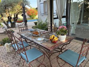 a table and chairs with food on a patio at Au Bon Mistral in Monteux