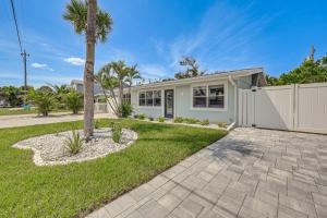 a palm tree in front of a white house at Steps to Englewood Beach Home with Outdoor Oasis! in Englewood