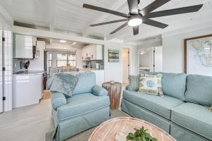 a living room with a blue couch and a ceiling fan at Steps to Englewood Beach Home with Outdoor Oasis! in Englewood