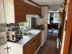 a kitchen with a sink and a counter top at Ruim chalet op een 5 sterren camping in Markelo +16 photos