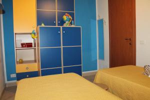 a room with two beds and a blue cabinet at Villa Antares in Custonaci