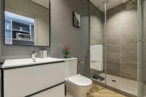 Un baño con inodoro, lavabo y ducha. en 1819 at one thibault apt, en Ciudad del Cabo 14 fotos más