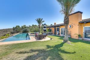 a house with a swimming pool and a palm tree at Stunning Valley and Mtn Views Elegant Temecula Home in Temecula