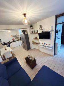 a living room with a blue couch and a tv at Adel Departamento - Ovalo Larco in Trujillo