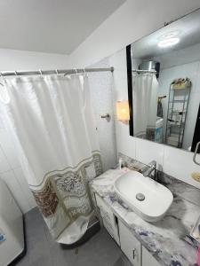 a bathroom with a sink and a shower curtain at Adel Departamento - Ovalo Larco in Trujillo