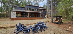 a group of chairs sitting in front of a house at Luxury Cabin- Sleeps 12- Hot Tub - Dog Friendly in Broken Bow