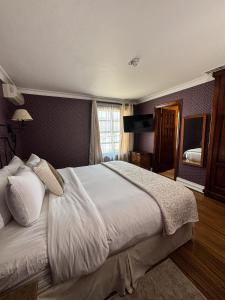 a bedroom with a large bed with white sheets at Hacienda San Angel in Ensenada