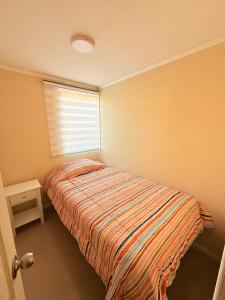 a small bedroom with a bed and a window at Departamento primer piso a minutos de la playa in Constitución