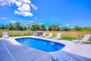 una piscina con sillas y una valla en 4056 - Tight Lines Tan Lines, en Playa de Kitty Hawk