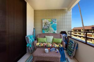 a porch with a chair and a table on a balcony at Beachside Condo with Ocean Views in Kailua-Kona
