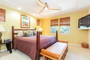 a bedroom with a bed and a flat screen tv at Mauna Lani Fairways - Luxury Accommodations in Waikoloa