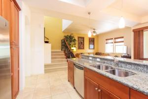 a large kitchen with a sink and a staircase at Mauna Lani Fairways - Luxury Accommodations in Waikoloa +29 photos