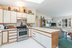 a kitchen with white cabinets and a stove top oven at Elk Forest Escape - Economy Family Abode in South Lake Tahoe